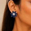 Blue floral statement earrings worn by model, focused jewellery view