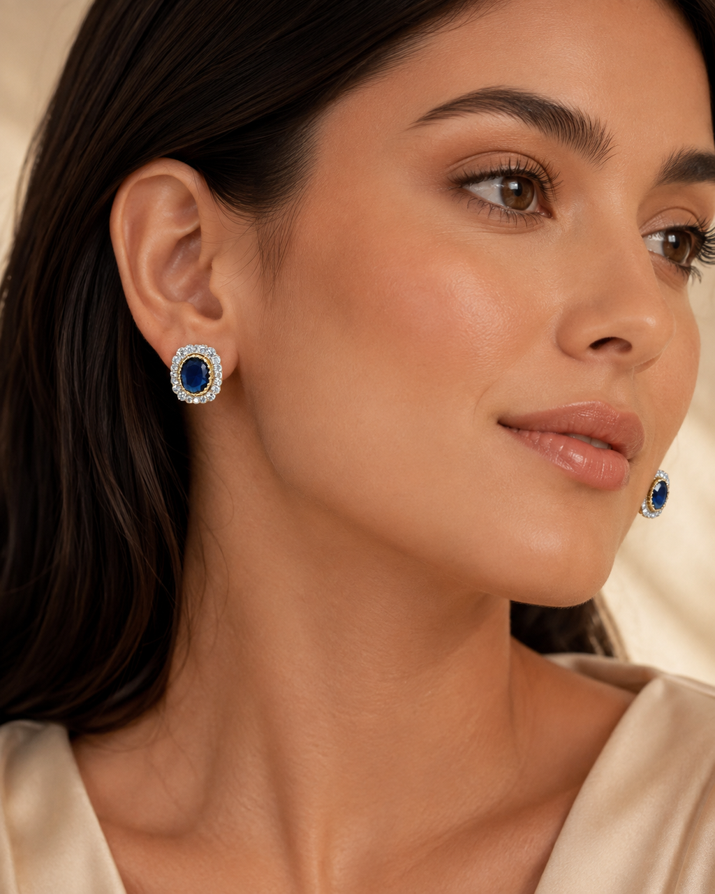 Model wearing Regal Oval Halo Stud Earrings in Sapphire Blue